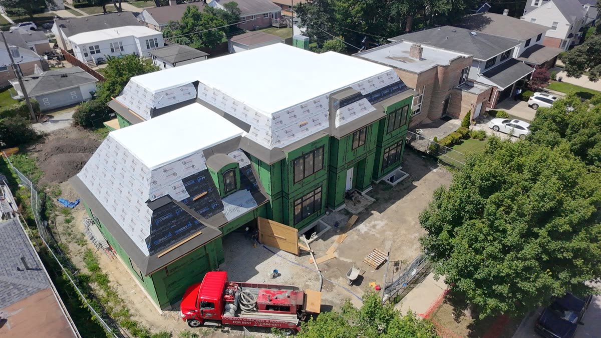 Aerial photo of a residential property mid-construction, roof and framing visible